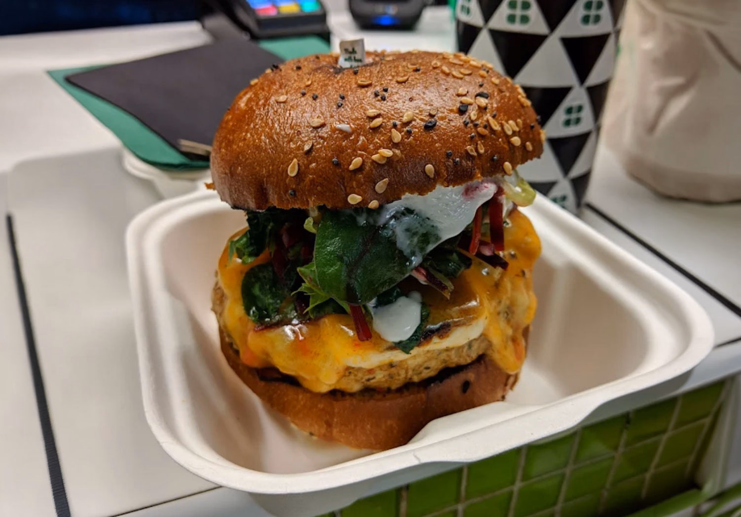 Original photograph of the same cheeseburger in a takeaway container